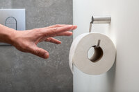 Bild: Hand die zum Klopapier greift 